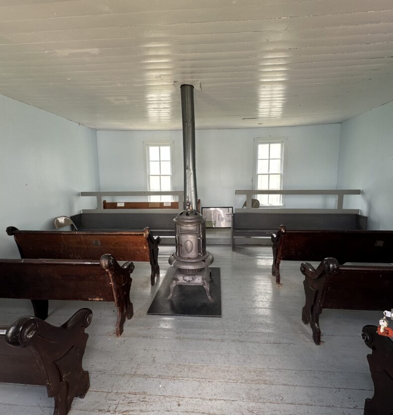 Meeting Room Interior Interior of a historic room with wooden pews and a central cast-iron wood-burning stove