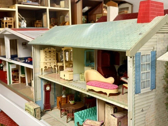 Vintage open-faced dollhouse with two floors of miniature furniture, including a pink chaise longue and a piano